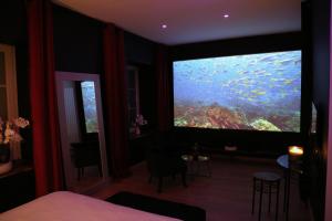 a room with a large window with a large aquarium at love room gold - les delices rooms in Angers