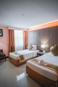 a hotel room with two beds and a window at Manila Grand Opera Hotel in Manila