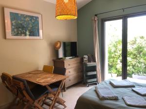 comedor con mesa, TV y ventana en Gîte de Notre Dame, en Saint-Étienne-du-Grès 40 fotos más