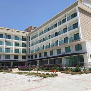 ein großes weißes Gebäude mit vielen Fenstern in der Unterkunft KALİYE ASPENDOS HOTEL in Antalya