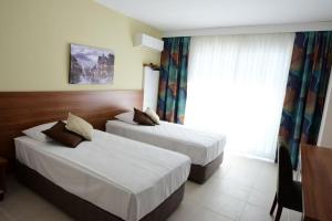 a hotel room with two beds and a window at KALİYE ASPENDOS HOTEL in Antalya