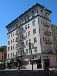 un edificio blanco alto en la esquina de una calle en Admiral Hotel, en San Francisco