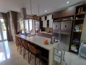 a kitchen with a large island with a counter and a refrigerator at The Luxury Home - Next to airport! in Kirkop