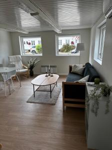 een woonkamer met een bank en een tafel bij Vejskrækgården in Fæbæk