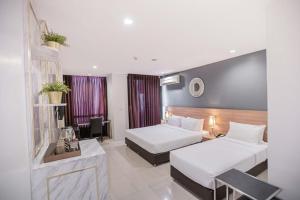 um quarto de hotel com duas camas e uma mesa em Marigold Sukhumvit em Bangkok