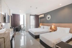 Habitación de hotel con 2 camas y cocina en Marigold Sukhumvit, en Bangkok
