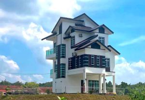 a large white building with black windows on top at Homestay Tok Ma 2 Gong Chempedak Marang in Marang