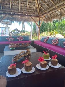 a table with four cakes on plates on it at Le Moya Beach in Nosy Be