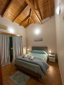Un dormitorio con una cama grande en una habitación con techos de madera. en Country house en Galatas