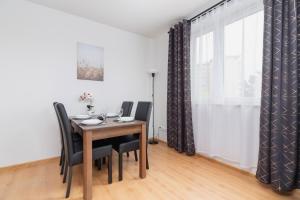 a dining room with a table and chairs and a window at Cozy Apartment with Balcony Chmieleniec by Renters in Krakow