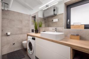 a bathroom with a sink and a washing machine at Villa Lomida Opatija in Opatija