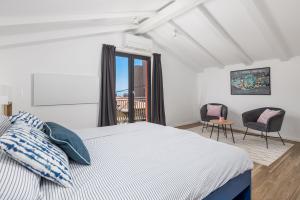 a bedroom with a bed and two chairs and a window at Villa Lomida Opatija in Opatija