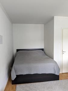 a bedroom with a bed and a white wall at Studio at Koulukatu in Savonlinna