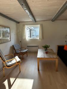 a living room with a table and a couch at Vejskrækgården in Fæbæk