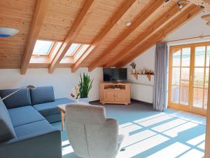 un soggiorno con divano blu e TV di Rabenhorst a Ofterschwang