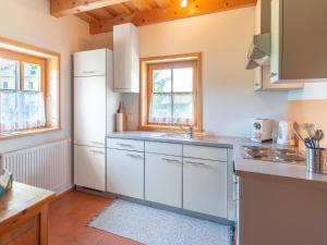 a kitchen with white cabinets and a white refrigerator at Berghütte Schwarzenberg, Urlaub in mitten der Natur in Schwarzenberg am Bohmerwald