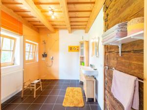 a bathroom with a sink and a wooden wall at Berghütte Schwarzenberg, Urlaub in mitten der Natur in Schwarzenberg am Bohmerwald