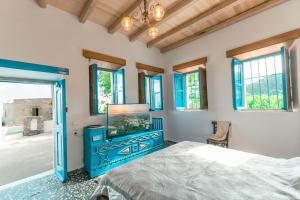a bedroom with a blue bed and a tv at Villa Historica in Asfendioú