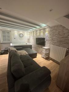 un soggiorno con divano e camino di Agréable Maison avec jacuzzi a Maisdon-sur-Sèvre