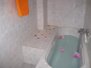 a bathroom with a bath tub with flowers in it at Antonis Tasios Guesthouse in Zagora