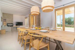 a dining room with a wooden table and chairs at Can Mosca in Cala Mendia