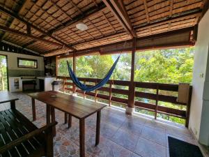 a large room with a wooden table and a hammock at Treetop Guesthouse and Bungalows in Sabang