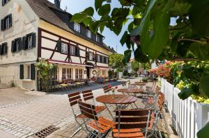 una calle con mesas y sillas y un edificio en Hotel Sonnenstube Hagnau, en Hagnau