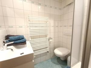 La salle de bains blanche est pourvue de toilettes et d'un lavabo. dans l'établissement Wikasa, à Ofterschwang