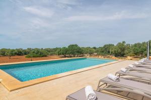 a large swimming pool with lounge chairs next to it at Can Maimó Nou in Santanyi