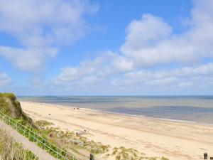 a beach with people on the sand and the ocean at Casabella in Hemsby