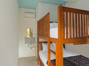 OYO 92558 Bale Datu Homestay في Montongbuwoh: سرير بطابقين في غرفة مع سلم