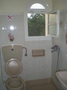 a bathroom with a toilet and a window and a sink at 8 KEYS by Katerina in Kalamaki