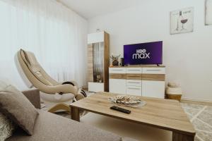 uma sala de estar com uma mesa de centro e uma televisão em Apartament Kraju centrum z fotelem masującym em Sosnowiec