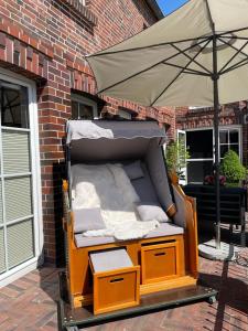 a bed with an umbrella on a patio at Burghaus 1 in Greetsiel