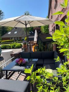 a patio with a couch and an umbrella at Burghaus 2 in Greetsiel