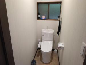a small bathroom with a toilet and a window at ゲストハウスみちしお 