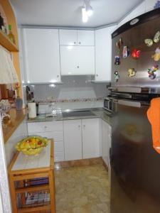 ラ・マタにあるApartment Viñamar 6 La Mataのキッチン(白いキャビネット、ステンレス製の冷蔵庫付)
