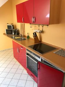 a kitchen with red cabinets and a sink at Pension Zur Linde in Berlstedt