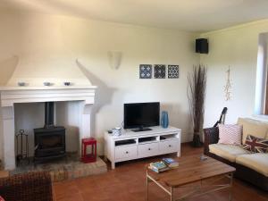 ein Wohnzimmer mit einem TV und einem Kamin in der Unterkunft Casa Trastulli in Castelfrentano