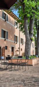 einer Gruppe von Stühlen und einem Tisch vor einem Gebäude in der Unterkunft AGRITURISMO Villino Bellavista in Spoleto