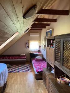 a room with a attic with a bed and a table at Lake Dreamhouse in Žuklijai