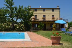 ein Haus mit Pool und Sonnenschirm in der Unterkunft Casa Trastulli in Castelfrentano