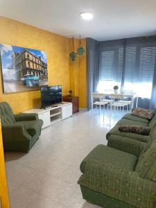 sala de estar con sofá, TV y mesa en Playa Y Cañas en Noja