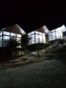 a large building with glass windows at night at Homestay view núi cực đẹp in Cham Ta Lao
