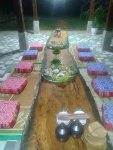 a long table with chairs and plates of food on it at Homestay view núi cực đẹp in Cham Ta Lao