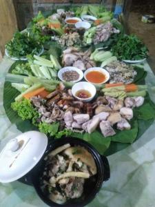 a bunch of vegetables on a plate on a table at Homestay view núi cực đẹp in Cham Ta Lao