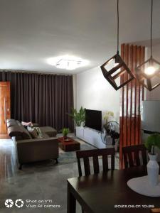 uma sala de estar com um sofá e uma mesa em MARLS PLACE FULLY FURNISHED, 4 mins walk to SM MALL and GAISANO MALL FB name Marls Place em Butuan