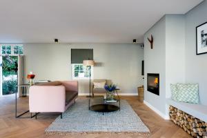 uma sala de estar com um sofá e uma lareira em Maison Cabrière - Boutique Suites em Franschhoek