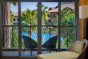 a room with a view of a pool seen through windows at Lapita, Dubai Parks and Resorts, Autograph Collection in Dubai
