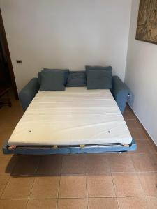 Bett in einem Zimmer mit blauem Sofa in der Unterkunft Casa Vacanze AURELIA in Biandronno